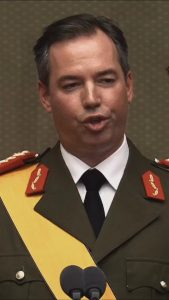 Grand Duke Guillaume of Luxembourg in ceremonial uniform with yellow sash speaking at microphones